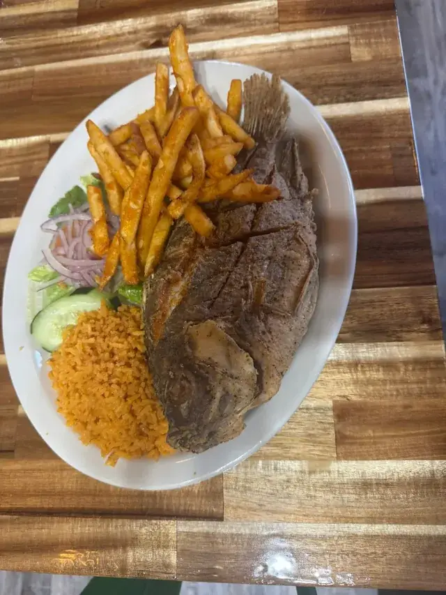 Whole fried fish with rice, fries, and salad at Nina's Tacos